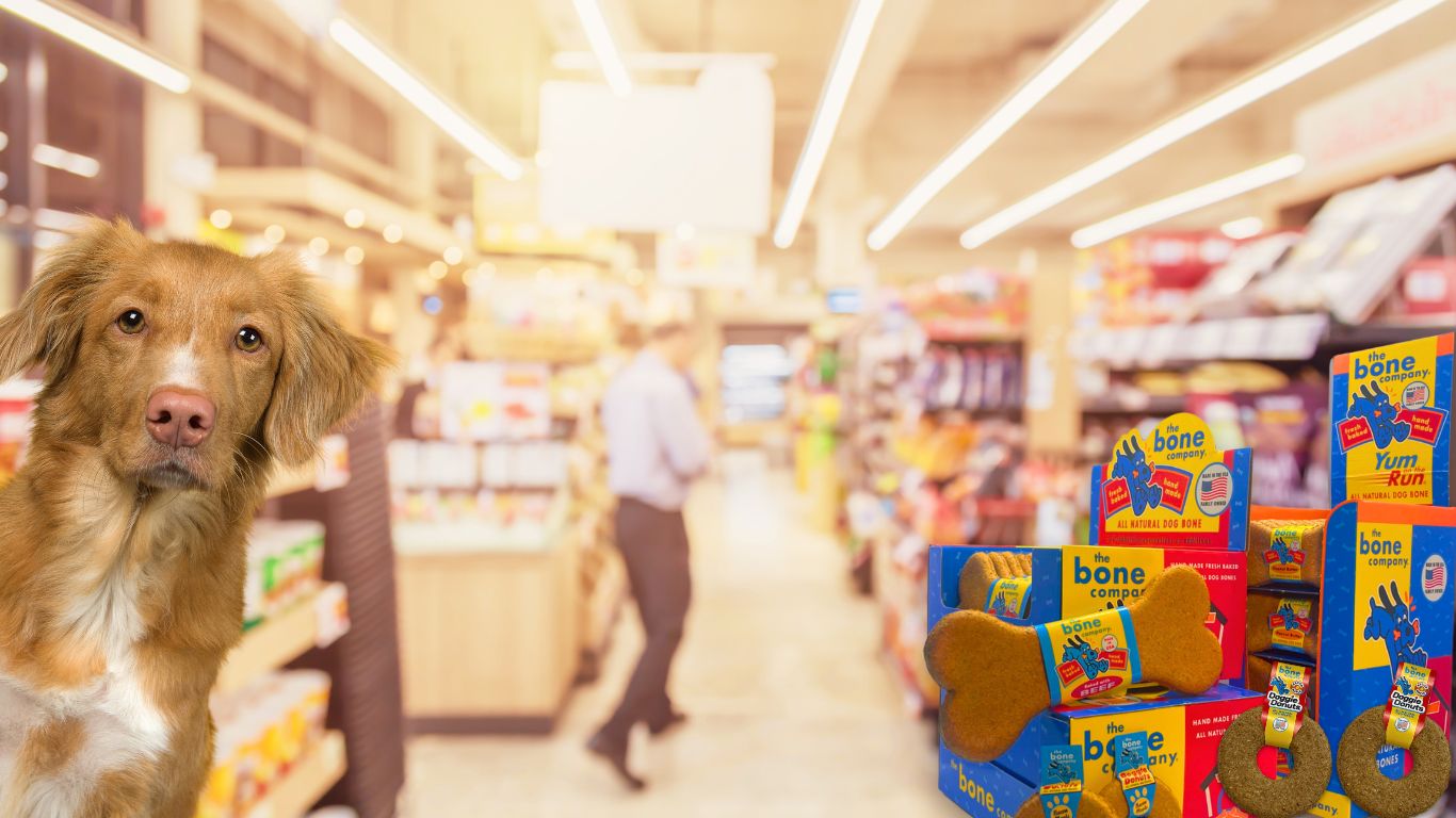 dog peeking at you from inside a convenience store features the bone company treats